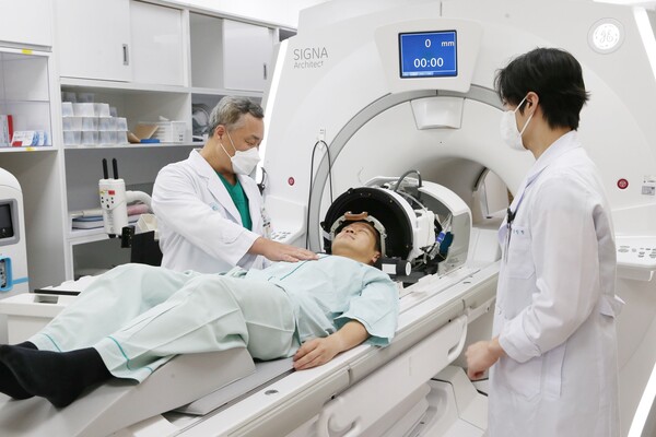 전상용 교수가 수전증 환자에게 전신마취와 두개골 절개 없이 진행되는 초음파 뇌수술에 대해 설명하고 있다. / 서울아산병원